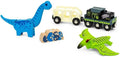 The Brio World Dinosaur Battery Train set includes a blue dinosaur figure, a yellow bus with black wheels, a black and green BRIO locomotive, a green pterodactyl, and a wooden log piece featuring a blue and yellow pattern.