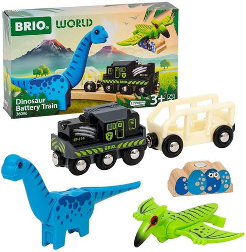 The image features the Brio World Dinosaur Battery Train by Brio. It includes a black and green battery-powered train engine, a white passenger car, a blue dinosaur figure, a green pterodactyl figure, and a small stone accessory with eggs. The box displays a mountain background perfect for any toy train adventure.