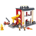 The Brio World Fire Station by Brio is a colorful playset that features a red and white building with a yellow slide, two toy fire trucks, a small fire flame prop, and two firefighter figures. This detailed fire station also includes windows and a garage door.