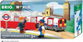 The Brio World London Underground Train by Brio is part of the Trains of the World series. The packaging displays a train with two toy figures: one in a suit and tie waving, and another in a cap and blue vest. Iconic landmarks such as Big Ben and Westminster Abbey can be seen in the background. Suitable for ages 3+.