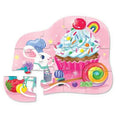 The Crocodile Creek 12pc Mini Puzzle - Celebration by Crocodile Creek is a vibrant toddler puzzle that showcases a whimsical scene with a white rabbit wearing a blue chef hat, a large cupcake adorned with rainbow sprinkles, and an assortment of candies set against a pink background. This puzzle is ideal for enhancing fine motor skills and hand-eye coordination, although it comes with two pieces missing.