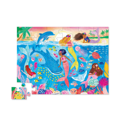 Dive into the enchanting world of the Crocodile Creek 36pc Floor Puzzle - Mermaid Dreams, a beautifully illustrated puzzle by Crocodile Creek, featuring mermaids swimming alongside dolphins, fish, and turtles in an underwater scene filled with coral reefs and sea plants. Above the water, a sky gradient transitions from pink to yellow for an added touch of magic.