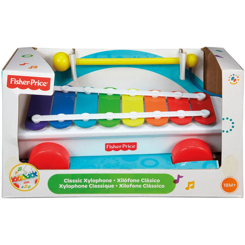 A Fisher-Price Classic Xylophone in its packaging. This musical toy features eight colorful, rainbow-colored keys and two yellow mallets. The packaging displays the product name in multiple languages, and the toy is suitable for ages 18 months and up.