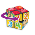 The Fisher-Price Laugh & Learn Puppy's Activity Cube is a colorful educational activity toy cube designed for toddlers. It features blocks with numbers 1 to 4, a red textured surface, and alphabet letters "A" and "B". An arrow pointing left suggests rotational movement. The cube pieces display bright colors and child-friendly illustrations characteristic of the Fisher-Price brand.