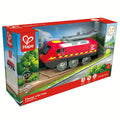 A toy train set in a box labeled "HAPE Charge n Go Train," designed for timeless play for children aged 3-8 years. The train is red with yellow stripes, and the packaging features images of tracks and grassy fields. A charging cable is included in the box, making it ready for endless adventures.