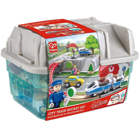 A HAPE City Train Bucket Set is displayed with 48 pieces. This city-themed set includes a blue and white train, track pieces, and various scenery items. All components are stored in a clear plastic storage box featuring a red and white label that showcases the train set in action, making it perfect for imaginative play.