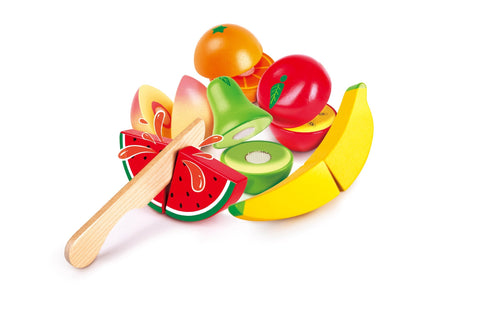 The HAPE Farm Shop Fruit Playset from HAPE features a colorful assortment of play fruits, including a watermelon slice, pear, orange, banana, apple, kiwi, sliced lemon, and strawberry. Among the fruits is a safe play knife. This vibrant collection is displayed on a white background and helps children develop fine motor skills.