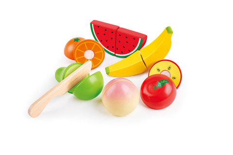 The HAPE Farm Shop Fruit Playset by HAPE features a delightful assortment of wooden fruits including a banana, watermelon, orange, tomato, apple, and pear. It includes a safe play knife for "cutting" the colorful fruits in half, making it perfect for enhancing fine motor skills. The toys are neatly arranged and inviting for imaginative play.