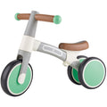 The HAPE My First Balance Bike - Green is a small children's three-wheeled adjustable balance bike featuring a green and white color scheme. It boasts two large wheels at the back, one at the front, a brown saddle, and green handlebar ends. Made by HAPE from lightweight aluminium alloy, this bike helps young children learn to balance and steer smoothly.