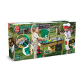 Box for the HAPE Outdoor Kitchen, designed for ages 3+. The image shows children enjoying outdoor play with the wooden toy playset. Elements include a working sink, cooking accessories, and a chalkboard for pretend play. Packaging highlights eco-friendly materials from HAPE.