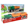 The packaging showcases the Hape Diesel Freight Train, a green and black train with orange freight cars, designed for children aged 3 and up. The background depicts a park setting with trees and a river. The text on the box reads "Diesel Freight Train" in both English and German, complemented by Hape magnetic boom cranes.