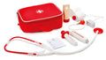 The Hape Doctor On Call children's playset by Hape features a red toy doctor's bag with a white cross on top, containing a stethoscope, syringe, thermometer, ointment tube, bandage roll, and a notepad with a pencil. All items in this medical kit are arranged neatly around the bag.