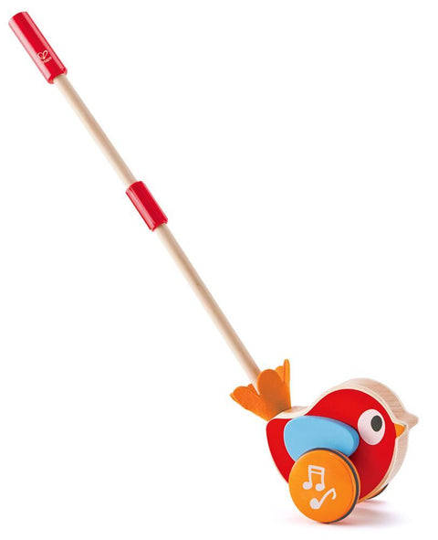 Introducing Hape Lilly Musical Push Along, part of the PEPE & FRIENDS collection by Hape. Ideal for ages 12 months and up, this vibrant wooden toy features a red body, blue wings, yellow accents, and an orange beak embellished with musical notes. Perfect for helping toddlers learn to walk, it comes equipped with a sturdy wooden stick featuring a red handle for easy pushing.