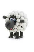 A charming clay sheep model with a fluffy, rounded white body made of small spheres and black head and legs, created using the Hey Clay 15 pack - Animals from Hey Clay for play-based learning. The sheep boasts blue eyes and a red tongue sticking out, all set against a white background.