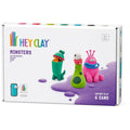 A box of Hey Clay 6 pack - Monsters (Cyclops, Terry, Pi) from the brand Hey Clay, suitable for ages 3 and up. The box showcases three vibrant clay monsters: a green creature in a bottle named Cyclops, a green and white bug-eyed monster called Terry, and a pink three-eyed monster named Pi. The set includes six cans of air-dry modeling clay that encourage play-based learning.