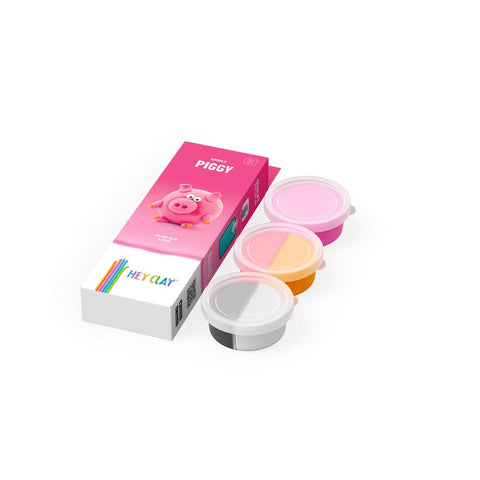 The "Hey Clay Single Pack - Piggy" modeling clay kit from Hey Clay is displayed. The set includes a box featuring an illustration of a pink pig and three open containers of clay in various colors: pink, orange, and white, making it perfect for sensory development.