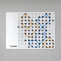 The Hey Doodle Silicone Activity Mat - 100 Squares (Large) features a game similar to tic-tac-toe on a reusable silicone mat. Orange and blue lines connect circles and X marks within the 100-square grid. The right side showcases numbered squares, while the left side remains blank, presumably for note-taking. This mat by Hey Doodle is also an excellent educational tool for teaching math.