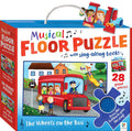 The Hinkler Musical Floor Puzzle - The Wheels On The Bus comes in a vibrant box that features an illustration of a red bus filled with children, accompanied by a driver, and a woman waiting at the bus stop. The set includes 28 giant puzzle pieces and comes with a sing-along book. A blue button that plays the iconic song is also highlighted on the cover.