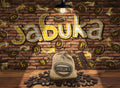 A burlap sack labeled "Jabuka - Twisting Letter Word Game" rests on a wooden floor, surrounded by scattered coffee bean-shaped game pieces. The brick wall behind features the word "Jabuka" in large, colorful graffiti letters, illuminated by a hanging light bulb, suggesting the exciting word game within.