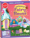 The image showcases the vibrant packaging for the Klutz Enchanted Fairy House book and activity kit by KLUTZ. The box is adorned with fairy illustrations and contains materials to create a whimsical craft set, featuring fairy dolls, a fairy-sized storybook, and glue. It also mentions that it includes a 28-page book.