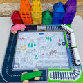 The Learn & Grow Rainbow Magnetic Tiles Toppers - Road Pack 40pc by Learn & Grow is a vibrant play set designed to spark imaginative play. It includes a road and rail track that encircles a central mat adorned with drawings of vehicles, trees, and buildings. Wooden cars and toy trains traverse the tracks, while brightly colored translucent plastic geometric shapes assemble into houses with the help of the Magnetic Tile Toppers.