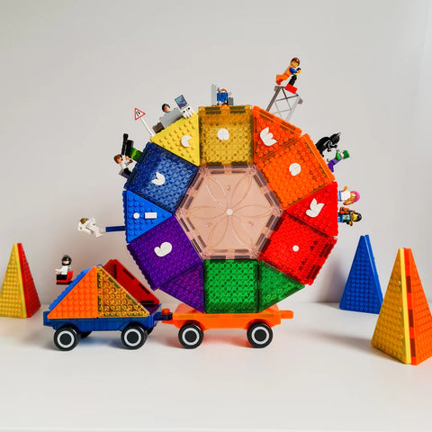 A colorful Ferris wheel made of LEGO bricks is displayed, featuring various mini-figures on each seat. Surrounded by brightly colored cones, small carts, and the innovative Magblox Twin Car Set for creative play, the scene becomes a vibrant playground full of imagination.