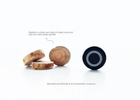 Image of Magblox Twin Car Set components. Three wooden discs cut from maple wood lie on the left, showcasing their natural texture, perfect for creative play. To the right, a black circular piece with a gray ring design is shown. Text indicates these Magblox toys are ethically and environmentally produced by Magblox.