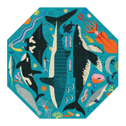 The Mudpuppy Octagon Shaped Puzzle - Ocean Life to Scale^ by Mud Puppy is an octagon-shaped delight featuring colorful illustrations of various ocean animals, including whales, dolphins, sharks, fish, and crabs against a turquoise background with coral and sea plants.