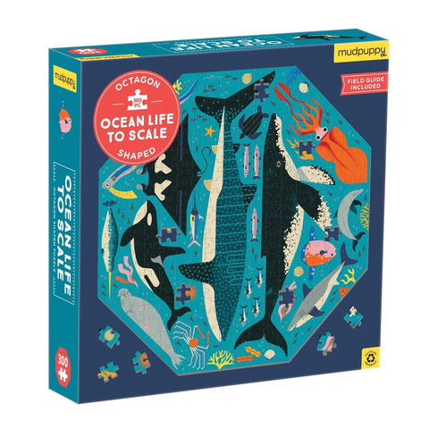 A brightly colored, octagon-shaped puzzle box titled "Mudpuppy Octagon Shaped Puzzle - Ocean Life to Scale^" by Mud Puppy. The cover features illustrations of various ocean animals, including whales, sharks, and fish. The box mentions that the Ocean Life Puzzle has over 300 pieces and includes a field guide.