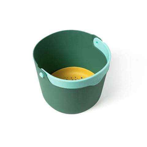 The QUUT Bucki Garden Green by QUUT is a dark green plastic bucket featuring a sky blue ergonomic clickable handle and a yellow perforated insert at the bottom. The handle attaches to the top edges, while the yellow insert acts as a strainer or separator within this modern design bucket, making it an essential for beach outings.