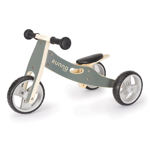 A compact balance bike for toddlers with a sleek design, featuring a light gray frame labeled "Runna Mini - Gumtree" in white letters, complemented by black seat and handlebars, and three wheels with white spokes.