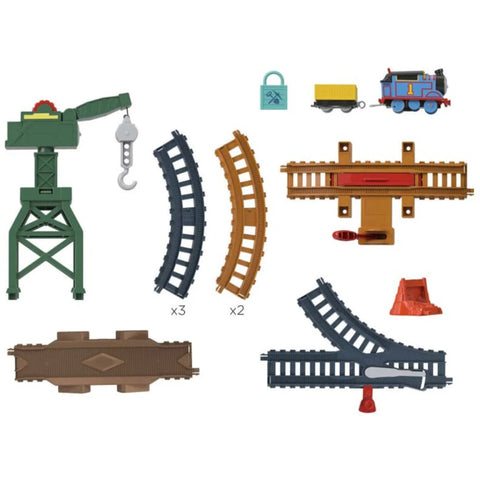 Assorted toy train set pieces, featuring tracks, a green crane with a hook labeled "Cranky the Crane" from the Thomas & Friends Motorized Engine collection by Fisher-Price, a blue and yellow train engine, a yellow cargo wagon, and various track structures and accessories, all arranged on a white background.