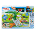 The packaging for the Thomas & Friends Talking Cranky Delivery Train Set by Fisher-Price features a vibrant design with blue and green accents. The front displays a toy train track alongside Cranky the Crane, highlighting exciting features such as over 325 phrases and compatibility with other tracks. It also includes a prominent "Try Me!" button for interactive engagement.