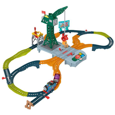 Introducing the Thomas & Friends Talking Cranky Delivery Train Set by Fisher-Price: A colorful toy train set featuring multiple tracks, bridges, and an overhead crane structure in the center. The tracks are green, yellow, and orange with connectors and a small blue engine pulling a purple car. Various signs and accessories are included for endless fun!