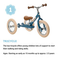 A white TryBike Steel with tan wheels designed for young children. This 2-in-1 tricycle features a brown saddle and wooden handle grips. Text below states it supports walking and riding skills, doubling as a balance bike suitable for ages 15 months to approximately 2.5 years.