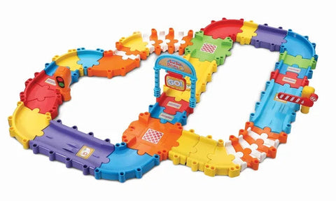 The Vtech Toot Toot Drivers Track Set by Vtech features interlocking pieces that form an infinity-loop shape. This colorful toy racetrack includes vibrant sections in red, blue, green, yellow, orange, and purple. It also boasts fun elements such as a starting gate labeled "GO!" and stop-and-go barriers.