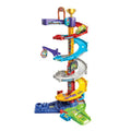 The Vtech Toot Toot Drivers Twist & Race Tower by Vtech is a vibrant, multilevel race track toy featuring spirals, ramps, and SmartPoint race cars. This dynamic playset includes a crane, a loop, and a trophy at the top. Multiple cars are poised on this versatile raceway, ready to speed down to the green base platform at the bottom.