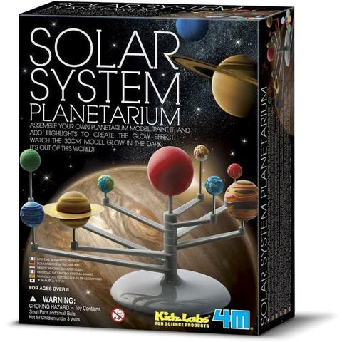 The image shows a boxed product labeled "4M Solar System Planetarium" by 4M. The front of the box depicts a completed solar system model with colorful planets on a stand. The planetarium kit also mentions that the planets can be painted and glow in the dark.