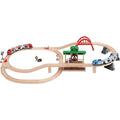 The Brio World Travel Switching Set by Brio is a wooden toy train set that features interconnected tracks with multiple loops and elevated sections. It includes red and blue battery-powered trains, a green central station, a red bridge, as well as small accessory figures and signs.