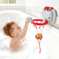 A young child with curly hair is enjoying bath or shower fun in a bubble-filled bathtub. The child reaches up to place a blue ball into the HAPE Bath Time Basketball Elephant Pal, which is attached to the side of the tub. This playful bath time setup from HAPE features an adorable elephant wearing red sunglasses and another ball inside the net.