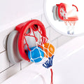 The HAPE Bath Time Basketball Elephant Pal by HAPE, a compact red and white toy basketball hoop, is securely attached to a tiled wall above the bathtub, creating an ideal bath time basketball experience. The net includes two colored balls in blue and orange. An inset image demonstrates the hoop folded into its compact position.