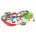 The HAPE Railway Bucket Builder Set by HAPE is a colorful wooden train set with 50 pieces that include multiple tracks, bridges, tunnels, and small buildings. The set features a blue train with cargo, a road with a blue car, and various traffic signs and trees. Build your own town with elevated tracks and a green hill for added fun.