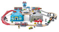 The HAPE Super Cityscape Transport Bucket Set by HAPE is a vibrant toy train set ideal for older children. It includes a miniature town complete with buildings, vehicles, and tracks. This set features two levels of train tracks, a red car bridge, a helipad with a toy helicopter, an airplane, and various accessories like trees, road signs, and figures.