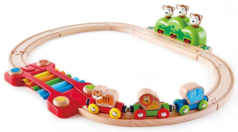 The Hape Music and Monkeys Railway by Hape is a charming wooden toy train set with animal-themed train cars featuring a tiger, lion, and elephant on a circular track. This delightful musical toy passes over a colorful xylophone and includes a green hill topped with three monkey figures, providing an exciting animal adventure for kids.