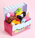 The Klutz Sew Your Own Donut Animals by KLUTZ comes in a colorful box with a striped lid, filled with plush toys resembling various animals and fruits such as a bear, pineapple, panda, and donut. The box is decorated with cartoon illustrations of donuts and the phrase "Donut start the party without us!" making it ideal for storing sewing kits or crafting felt donuts.