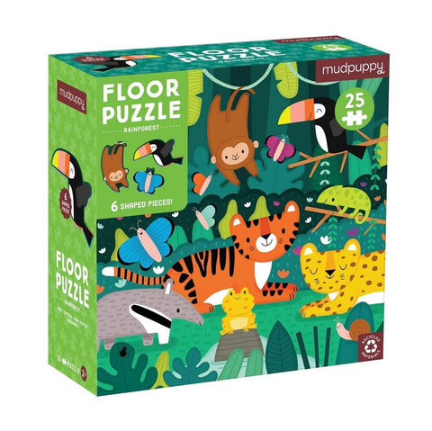 The image shows a Mud Puppy 25-piece Floor Puzzle titled "Rainforest." The box, made from recycled materials, is mainly a vibrant green and features illustrated rainforest animals such as a tiger, frog, monkey, toucan, butterflies, and jaguar. The puzzle includes 25 oversized pieces with six shaped pieces.