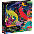 The Mudpuppy 500-piece Illuminated Glow in the Dark puzzle - Dinosaurs showcases various colorful dinosaurs in a vibrant jungle scene. This family activity promises fun for all ages with its special glow-in-the-dark feature. The Mudpuppy brand is prominently displayed in the top right corner of the box.