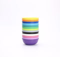 A neatly stacked set of nine vibrant REPLAY Re-Play Bowls, made from recycled plastic, sits one on top of the other against a plain white background. Safe for kids, this colorful tableware set by REPLAY features yellow, orange, light green, dark green, blue, black, white, pink, and purple bowls from top to bottom.