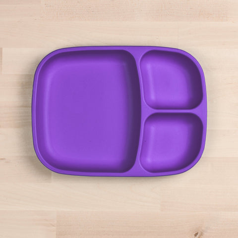 A REPLAY Re-Play Divided Tray in purple, made from recycled material, featuring one large section and two smaller sections sits on a light wooden surface.