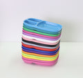 A neat stack of Re-Play Divided Trays from REPLAY, eco-friendly and made from recycled material, each featuring compartments. This durable tableware comes in a variety of vibrant colors, including blue, pink, green, red, black, yellow, and purple. The background is a plain white surface.